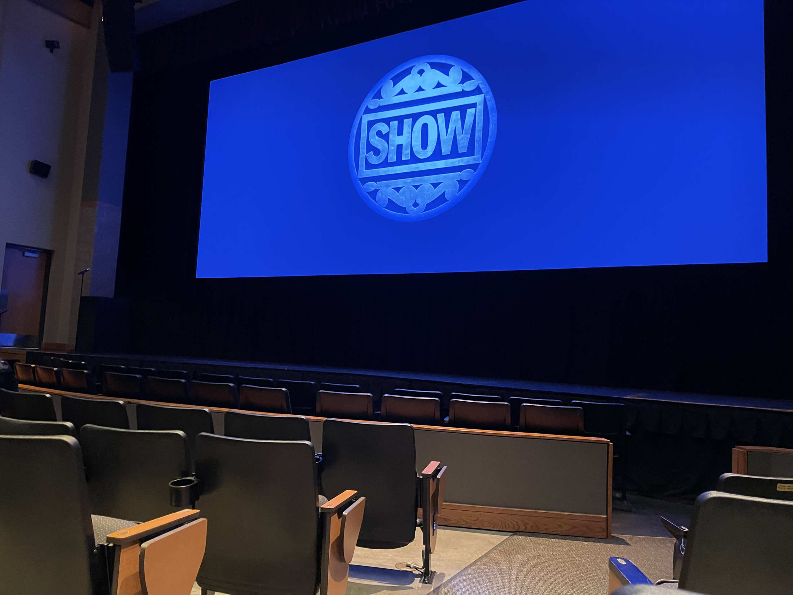 Empty theater with "Show" projected on screen.