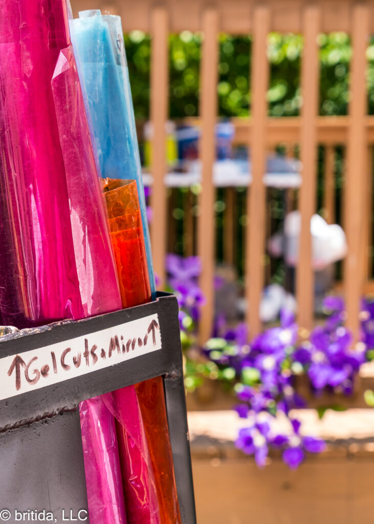 Rolls of production gels contrast with flowers in the yard on Day 1.